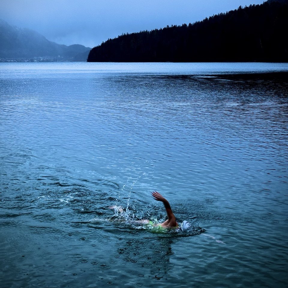 Ines Hahn schwimmt bei Regen in einem dunklen, kalten Bergsee