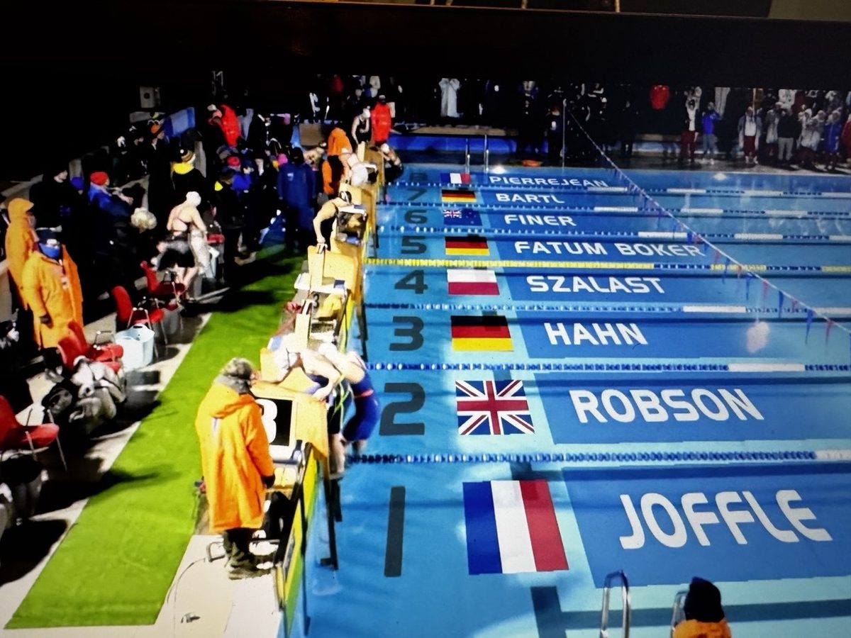 Startblöcke bei einem Eisschwimm-Wettkampf, auf Bahn 3 der Name Hahn mit deutscher Flagge